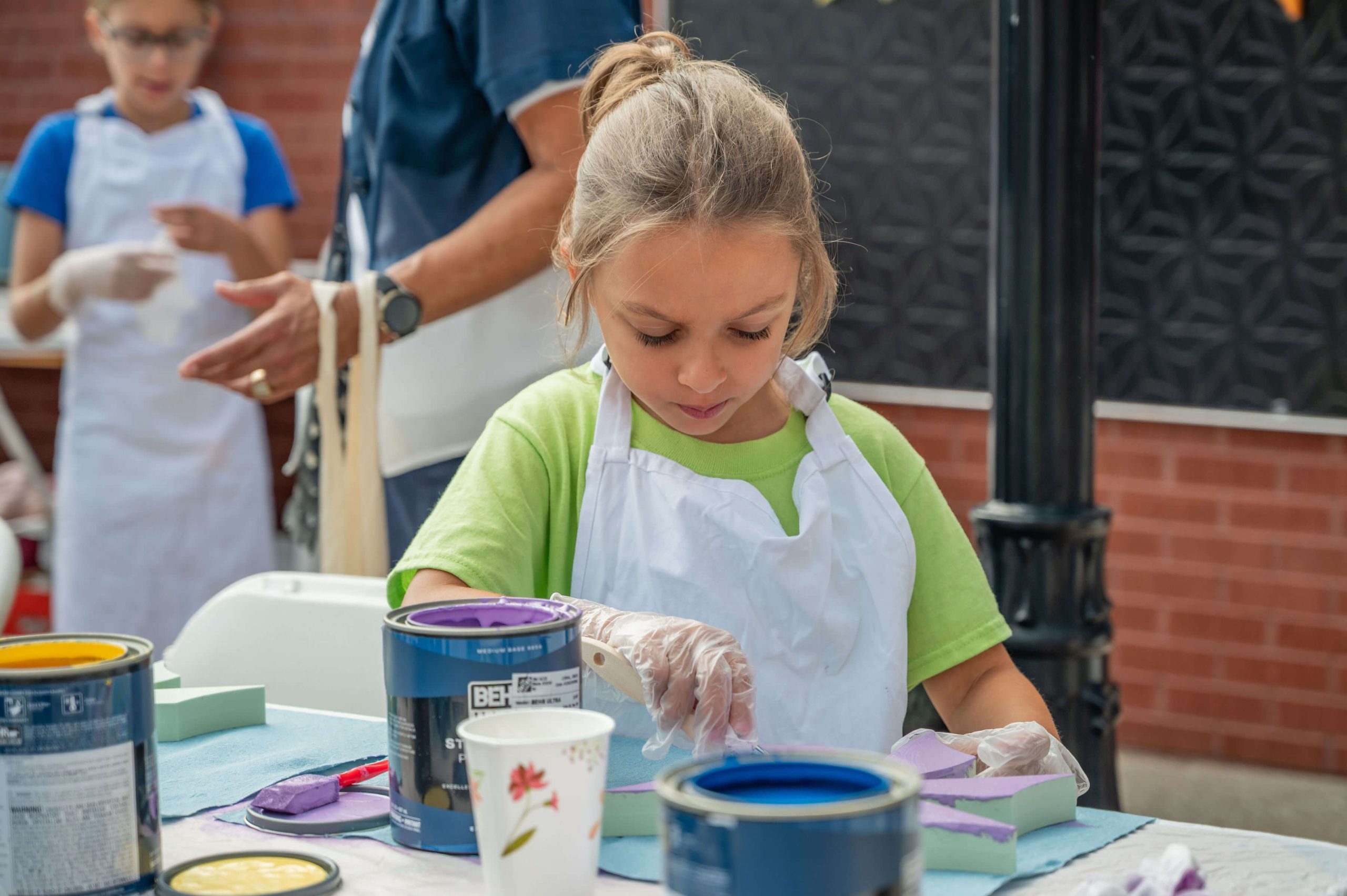 Girl painting an interactive "Mural for ALL" mural project