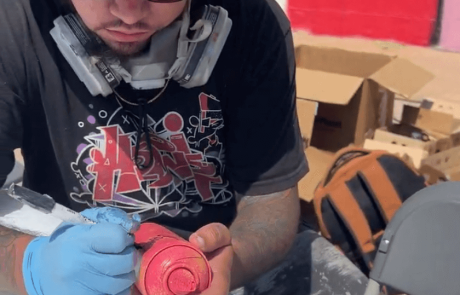 Artist Gabe Barajas autographing paint cans at Mural Walk 2024 in Valparaiso, IN